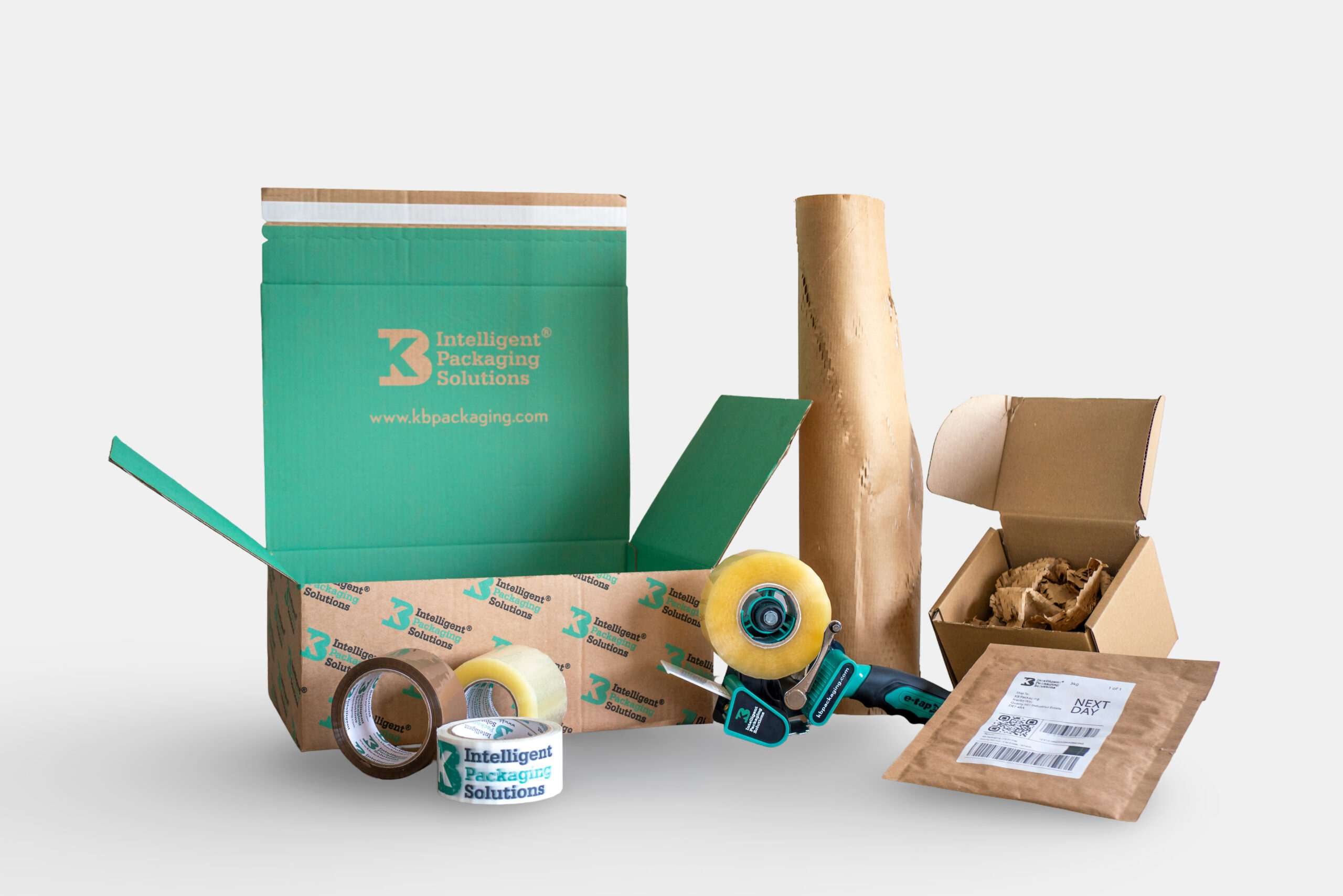 Packaging materials including a corrugated cardboard box, packaging tape, kraft paper, postal packaging, and void fill materials used for packing and shipping products.