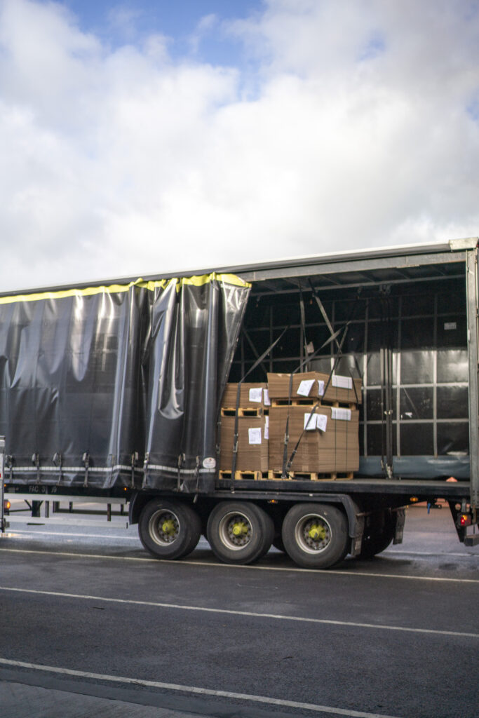 Cardboard boxes stacked on a pallet inside a delivery lorry, ready for posting and distribution in various box sizes
