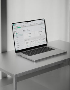 Laptop displaying the KB Packaging Online Portal dashboard, showing account information, order management tools, live pricing, and purchasing features on a desk in a modern office setting.